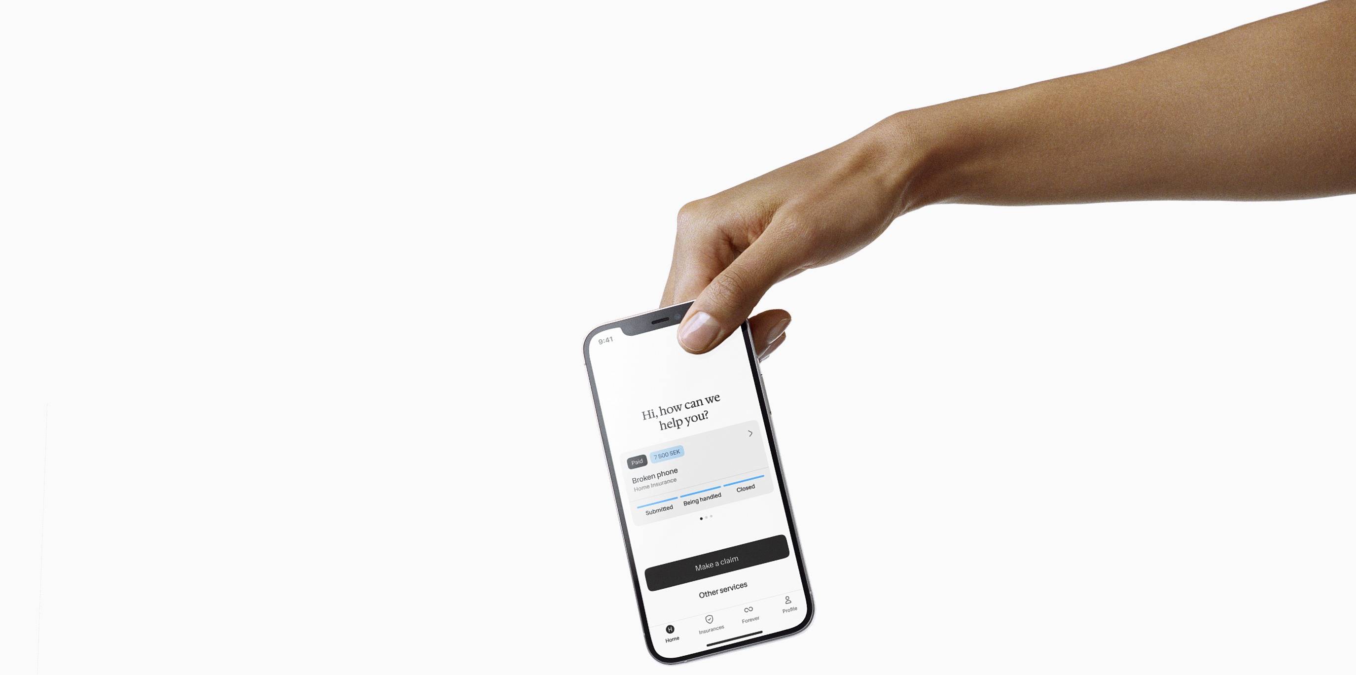 A mobile phone with Hedvig insurance app held by hand.
